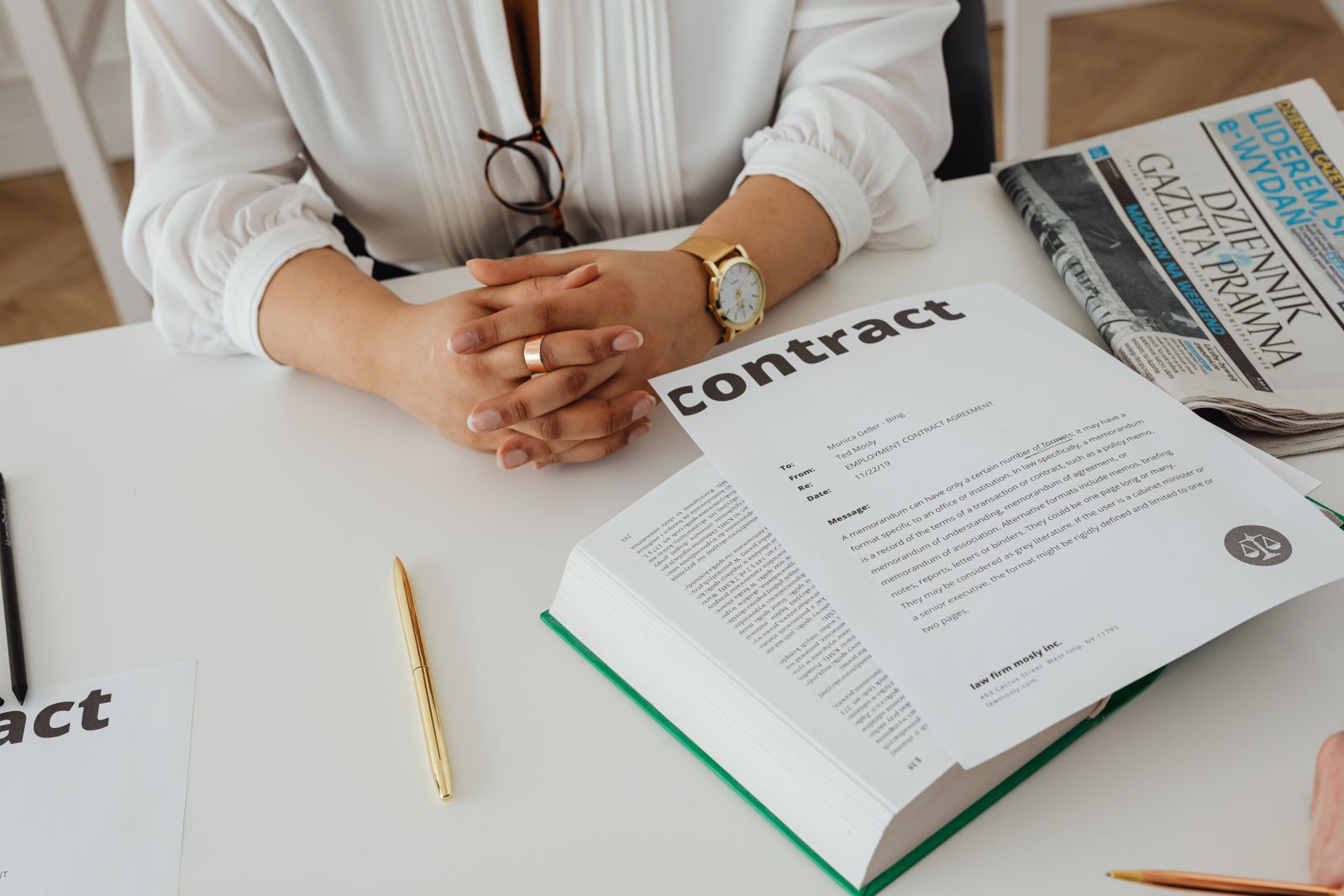 Contract paperwork on a desk beside a newspaper